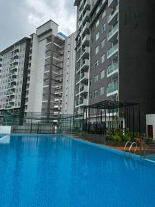 a large blue swimming pool in front of some buildings at Ilsham Guest House @ Seroja Hills BBST Sepang in Sepang
