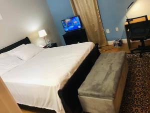 ein Hotelzimmer mit einem Bett, einem Sofa und einem TV in der Unterkunft Room in House - Executive Private Room in Alexandria