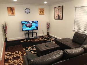 ein Wohnzimmer mit einem Sofa und einem Flachbild-TV in der Unterkunft Room in House - Executive Private Room in Alexandria