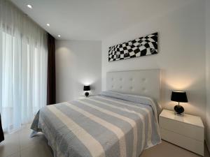 ein Schlafzimmer mit einem Bett mit einer karierten Decke in der Unterkunft Luxury family apartment Equilibrium by AltamarHomes in Palm-mar + 46 Fotos