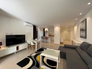 ein Wohnzimmer mit Sofa und Fernseher in der Unterkunft Luxury family apartment Equilibrium by AltamarHomes in Palm-mar