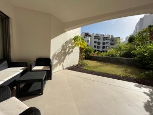 un patio con mesas y sillas y vistas a un edificio en Luxury family apartment Equilibrium, en Palm-mar