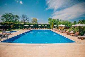 a large swimming pool with lounge chairs and umbrellas at Sapanca Cayir Cimen Otel in Sapanca