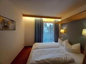 a hotel room with a bed and a window at Residence Alpenrose in Sesto