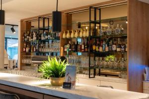 eine Bar mit vielen Flaschen Alkohol auf Regalen in der Unterkunft Hotel MeerZeiten inklusive externer Schwimmbad- & Saunanutzung in Bensersiel