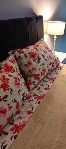 a bed with two pillows with red flowers on it at Departamento Centrico Tandil 9 de Julio 454 in Tandil