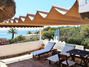 eine Terrasse mit einem Tisch und Stühlen unter einem Dach in der Unterkunft Mandala Bungalows - Adults Only in Los Caños de Meca