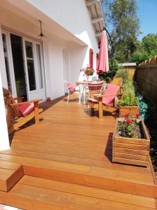 une terrasse en bois avec des chaises, une table et un parasol dans l'établissement lilou, à Biganos