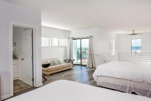 Habitación blanca con cama y sofá en Barefoot Wishes en Oceano
