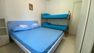 een slaapkamer met 2 stapelbedden met blauwe lakens bij Sun Ste in Lido di Pomposa