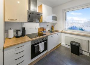 a kitchen with white cabinets and a sink and a window at Modern 3-BR Apmt. Sleeps 6+ (Martin-der-Meisterliche) in Essen