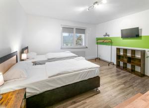 a bedroom with two beds and a flat screen tv at Modern 3-BR Apmt. Sleeps 6+ (Martin-der-Meisterliche) in Essen