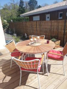 une table et des chaises en bois sur une terrasse en bois dans l'établissement lilou, à Biganos