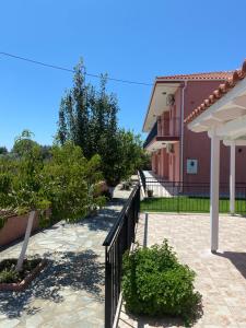 a walkway in front of a building with a fence at Paradise Studios in Svoronata