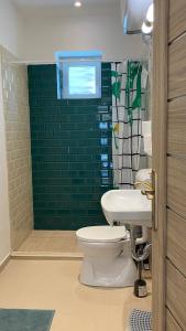 baño con aseo y pared verde en Night & Flight Airport Apartman, en Vecsés