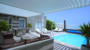 a patio with a couch and a swimming pool at Villa Patricia Playa Blanca in Playa Blanca