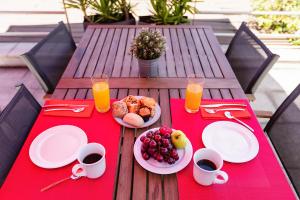 een picknicktafel met borden met eten en sinaasappelsap bij Hotel ibis Guimaraes in Guimarães