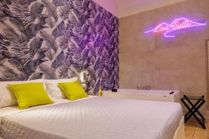 a bedroom with a bed and a neon sign on the wall at Live suite Napoli in Naples