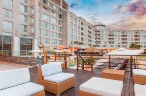 - une vue sur le balcon d'un hôtel avec des chaises et des tables dans l'établissement Wyndham Nordelta Tigre - Buenos Aires, à Tigre