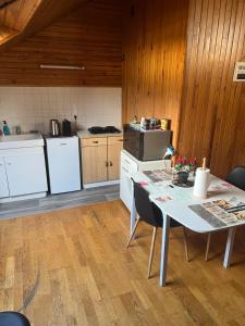 a kitchen with a table with chairs and a refrigerator at Studio en plein coeur Tulle in Tulle