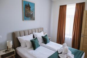 Un pat sau paturi într-o cameră la AVIOR Garni Hotel