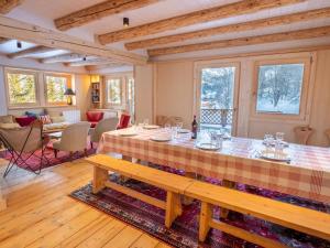 una sala da pranzo con un tavolo e un divano di Chalet spacieux Méribel · Ski aux pieds · Cheminée - FR-1-688-34 a Méribel Altre 7 foto