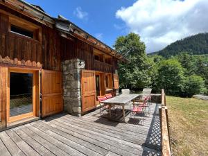 una terrazza in legno con tavolo e sedie su una cabina di Chalet spacieux Méribel · Ski aux pieds · Cheminée - FR-1-688-34 a Méribel