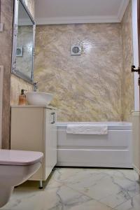 a bathroom with a sink and a toilet and a tub at Apartament ILEV in Roman