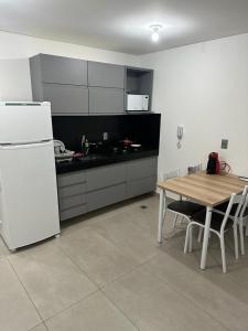 uma cozinha com uma mesa e um frigorífico branco em Apartamento à 100 metros da praia. em João Pessoa