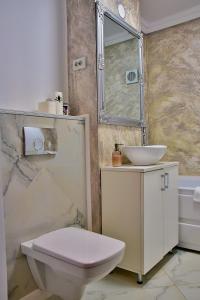 a bathroom with a white toilet and a sink at Apartament ILEV in Roman