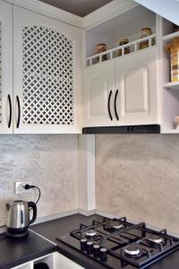 a kitchen with white cabinets and a stove top oven at Apartament ILEV in Roman