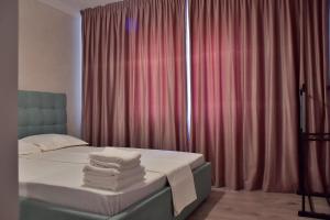 - une chambre avec un lit et des serviettes dans l'établissement Apartament ILEV, à Roman