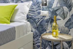 a bedroom with a bottle of champagne on a table next to a bed at Live suite Napoli in Naples