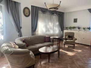 - un salon avec un canapé et une table dans l'établissement Luxuria Central Villa Bucharest, à Bucarest