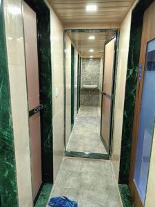 a corridor of a bathroom with green marble walls at Kohinoor Dormitory in Mumbai