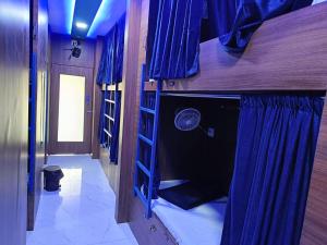 a room with two bunk beds with blue curtains at Kohinoor Dormitory in Mumbai