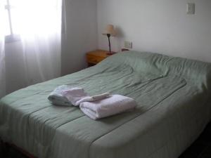 a bed with two towels sitting on top of it at Brisa de los Molles in Los Molles +39 photos