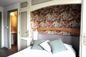 1 dormitorio con 1 cama con pared de flores en Domaine "Le Ry d'Ave", en Rochefort