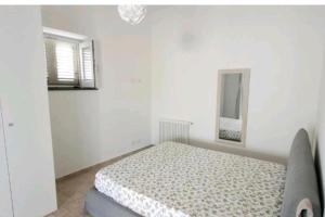 Habitación blanca con cama y espejo en Casa Eoliana en Lipari