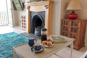 a coffee table in a living room with a fireplace at Sandy Feet Retreat - Castlerock in Castlerock