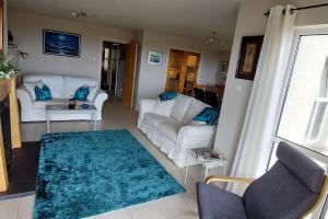 a living room with two white couches and a blue rug at Sandy Feet Retreat - Castlerock in Castlerock