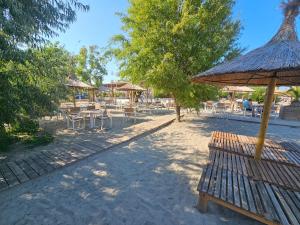 a group of tables and umbrellas on a beach at Summer Crib Mamaia-Sat in Mamaia Nord