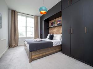 a bedroom with a bed and a large window at Pass the Keys One bedroom APT near popular London attractions in London