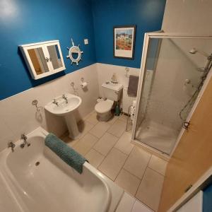 卡色洛克的住宿－Sandy Feet Retreat - Castlerock，带浴缸、盥洗盆和卫生间的浴室