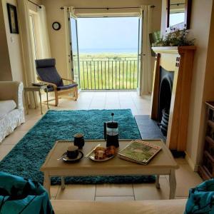 un soggiorno con tavolino e camino di Sandy Feet Retreat - Castlerock a Castlerock