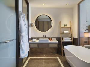 a bathroom with a tub and a sink and a mirror at City of Dreams Mediterranean - Integrated Resort, Casino & Entertainment in Limassol
