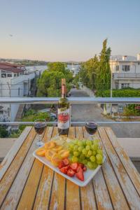 un piatto di frutta e una bottiglia di vino su un tavolo di Huzur Royal Hotel a Datça