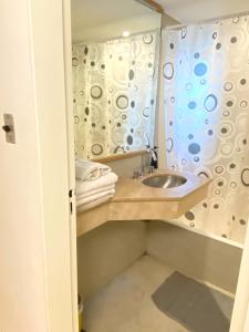 a bathroom with a sink and a shower curtain at Apart hotel Ciudad de Bs As in Buenos Aires