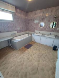 ein großes Bad mit einer Badewanne, 2 Waschbecken und einer Badewanne in der Unterkunft Gite LE 45 TOURS in Nueil-sous-les-Aubiers
