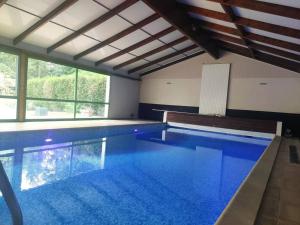 a large indoor swimming pool with blue water at Gite LE 45 TOURS in Nueil-sous-les-Aubiers